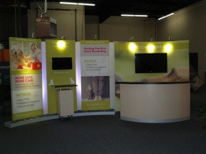 Custom 10 x 20 Exhibit with Large Format Pillowcase Graphics, Closet Storage, Reception Counter, and Pedestal. Re-configures to 10 x 10
