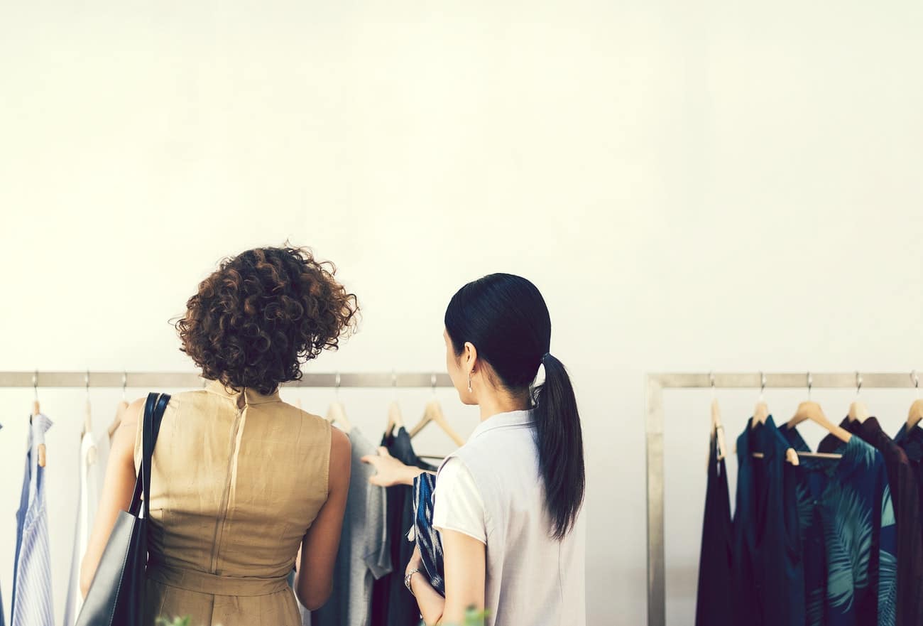 two women checking outfits in trade show